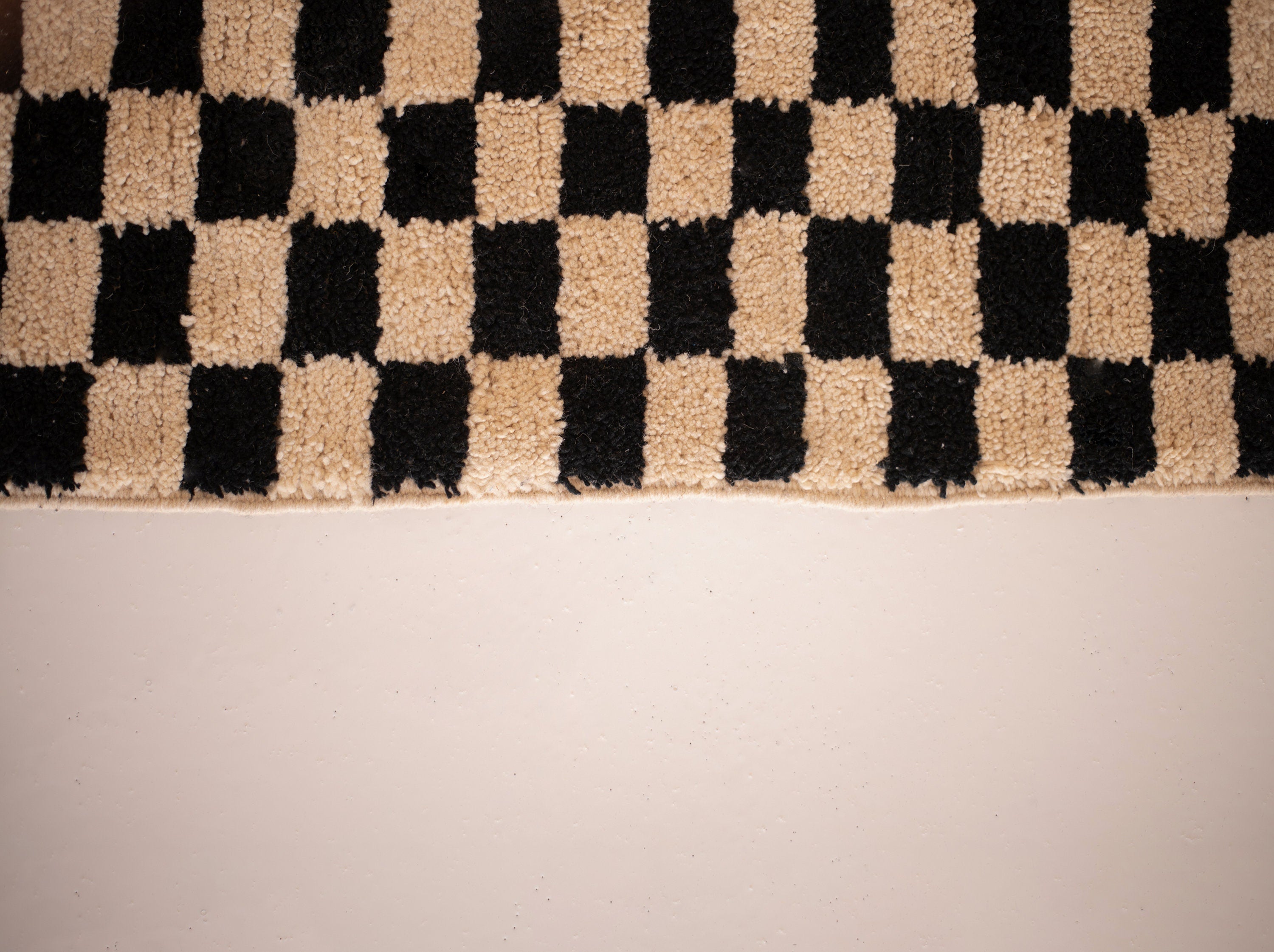 Black and beige checkered rug, perfect for modern home decor and comfort.