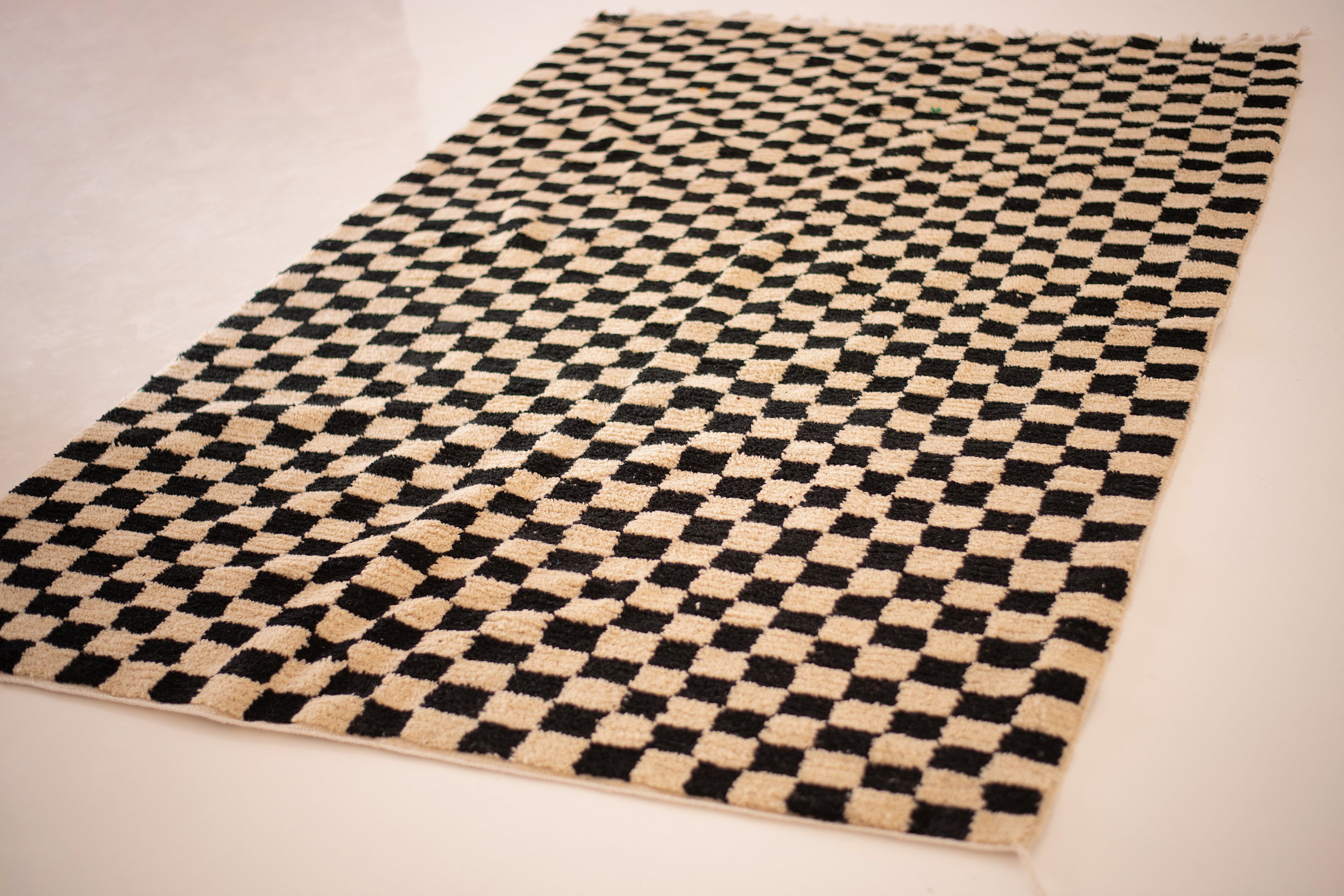 Black and beige checkered rug, perfect for modern home decor and stylish interiors.