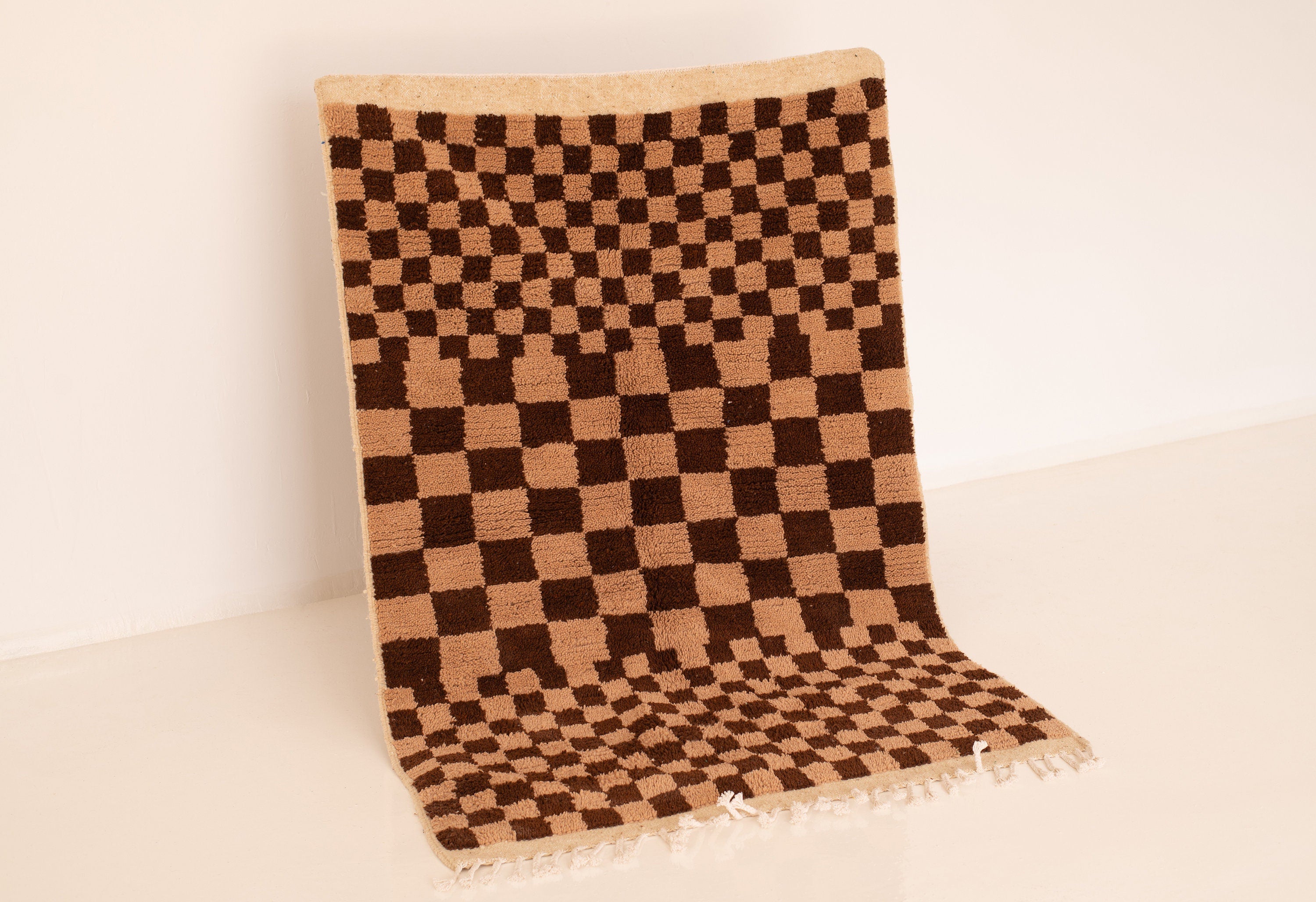 Brown and beige checkerboard patterned rug, perfect for stylish home decor.