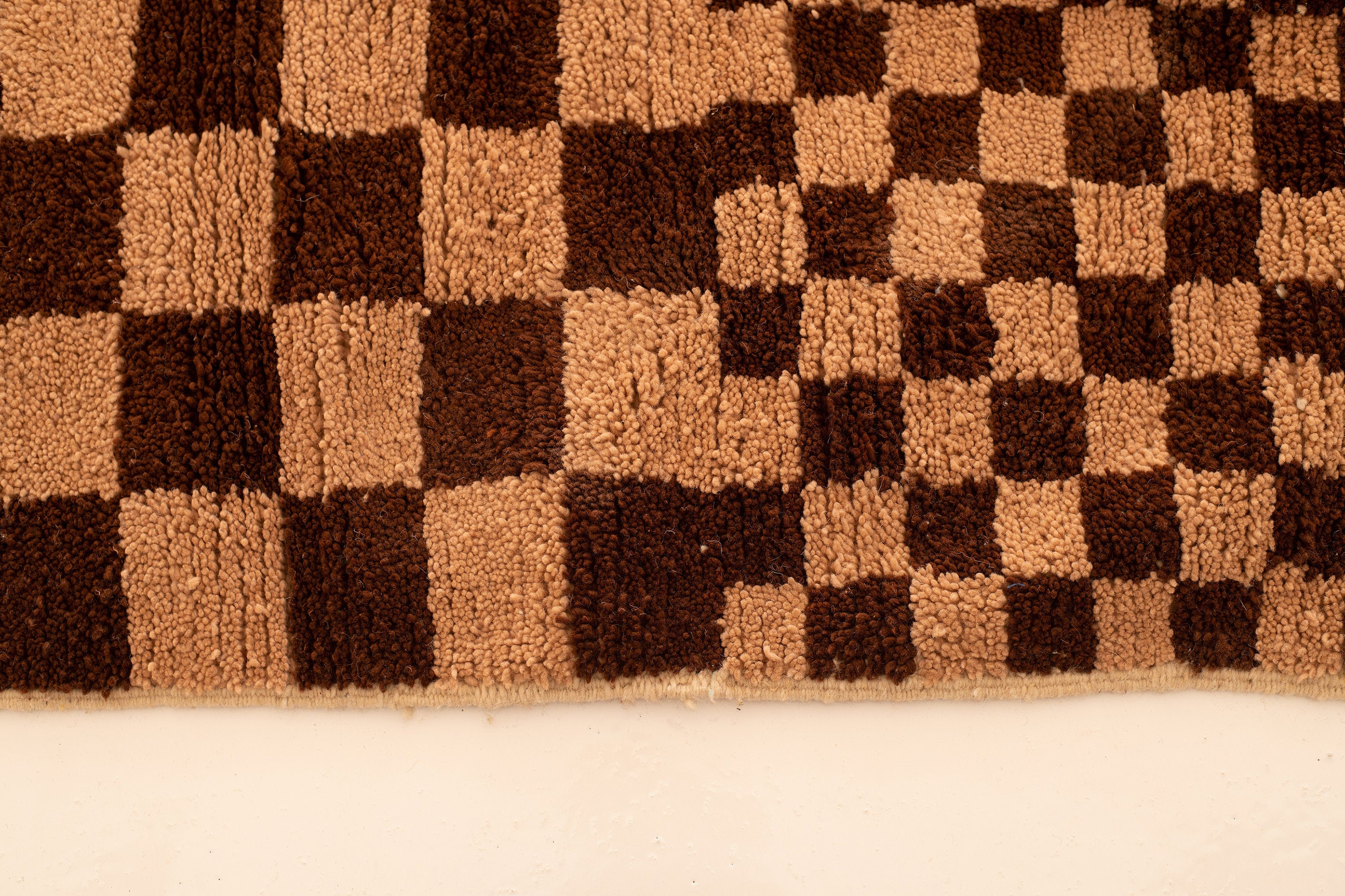 Brown and beige checkerboard rug, perfect for adding warmth to any space.