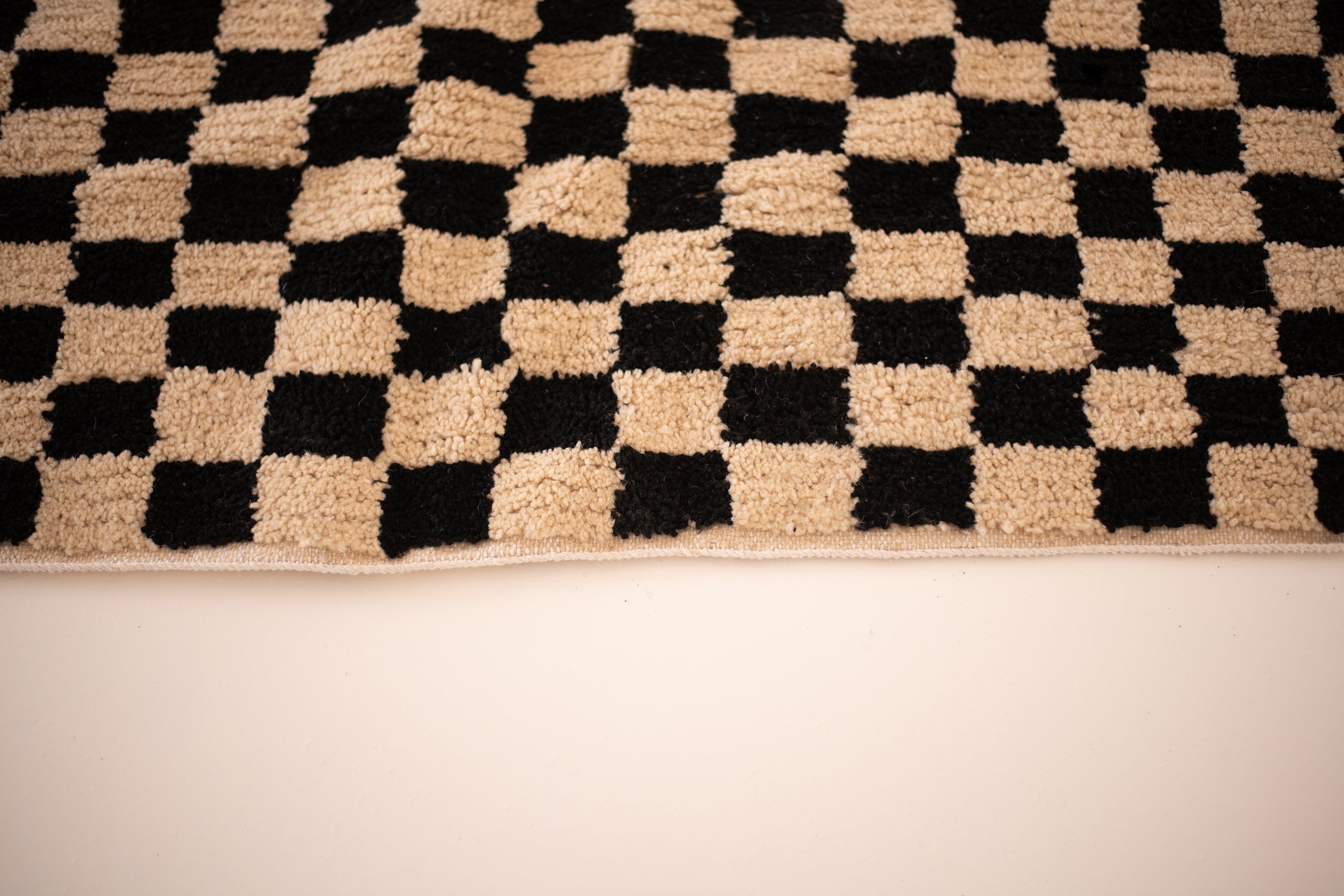 Black and beige checkerboard fluffy rug, perfect for enhancing home decor and comfort.