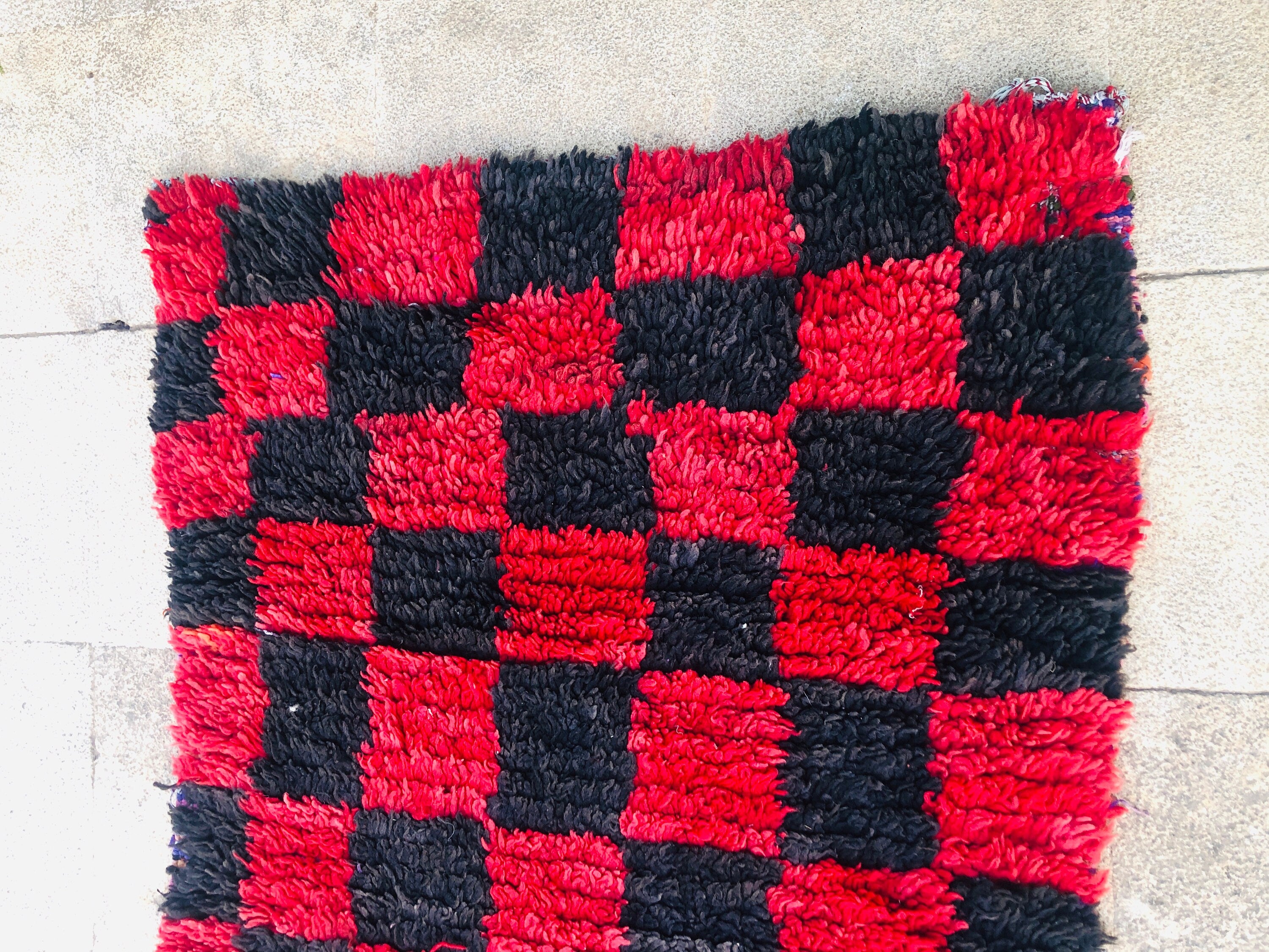 Red and black checkered rug, plush texture, perfect for modern home decor.