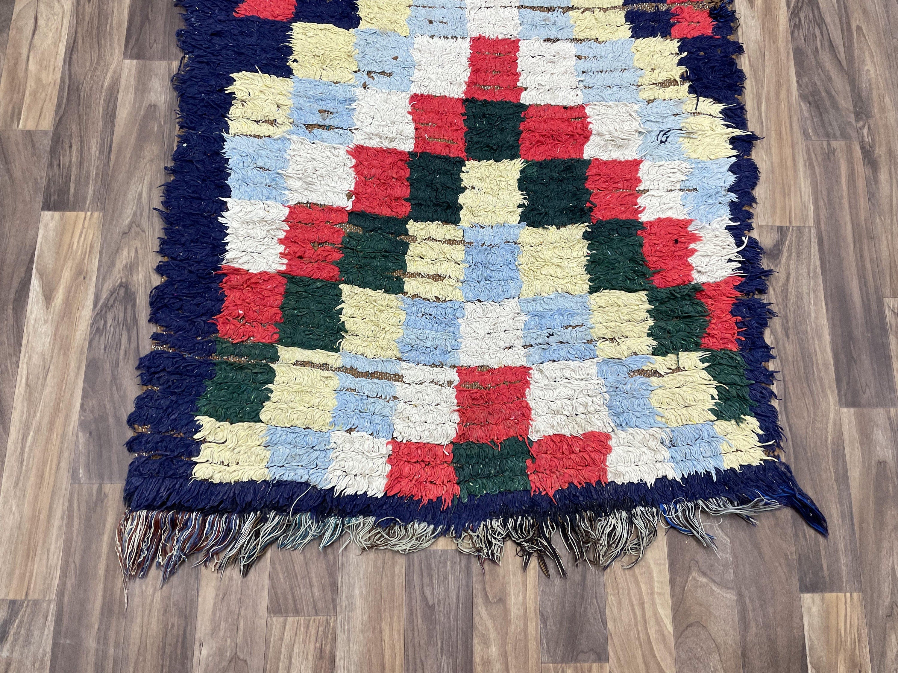 Colorful handwoven rug featuring a unique patchwork design and fringed edges.