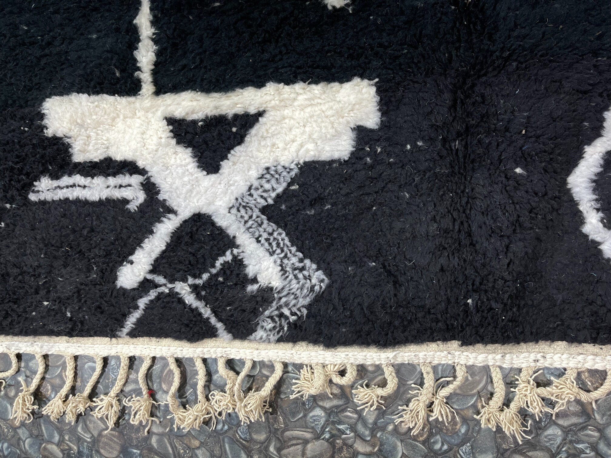 black and white patterned rug with fringes