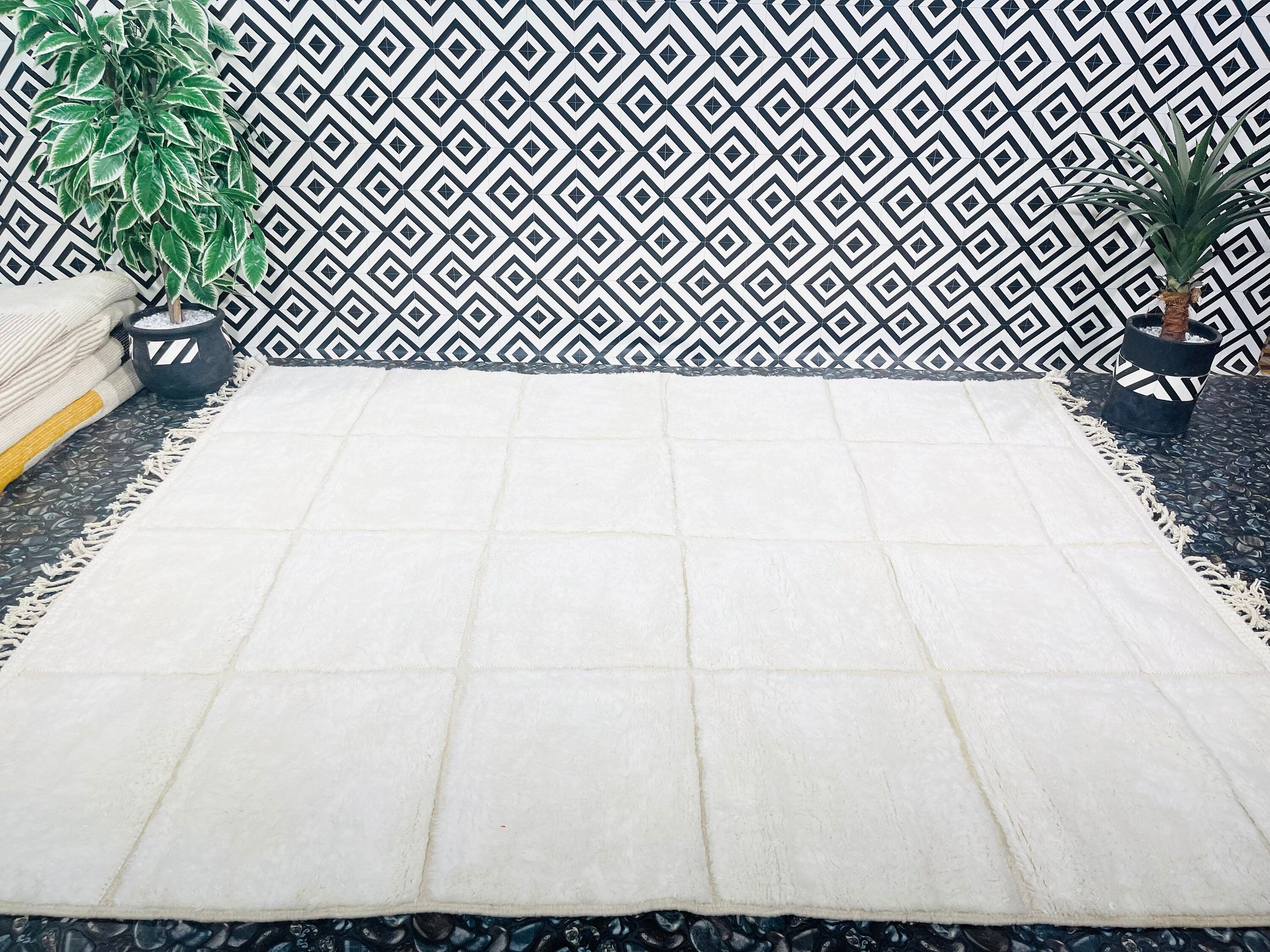 textured cream rug against patterned black wall