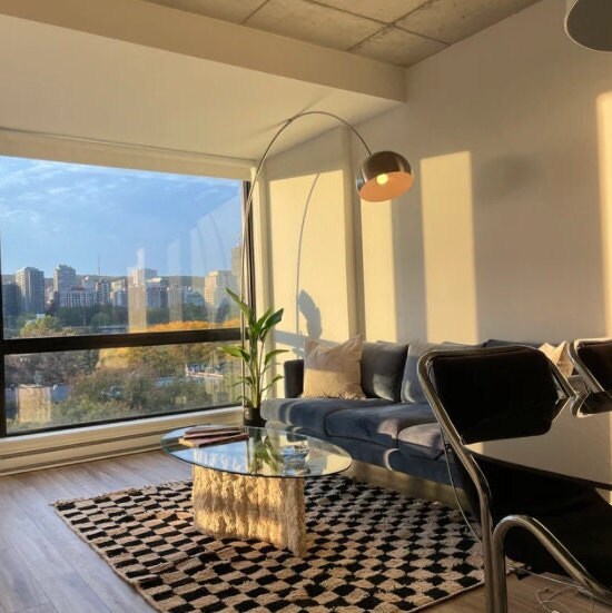 Stylish living room with modern decor, large window, and city view.