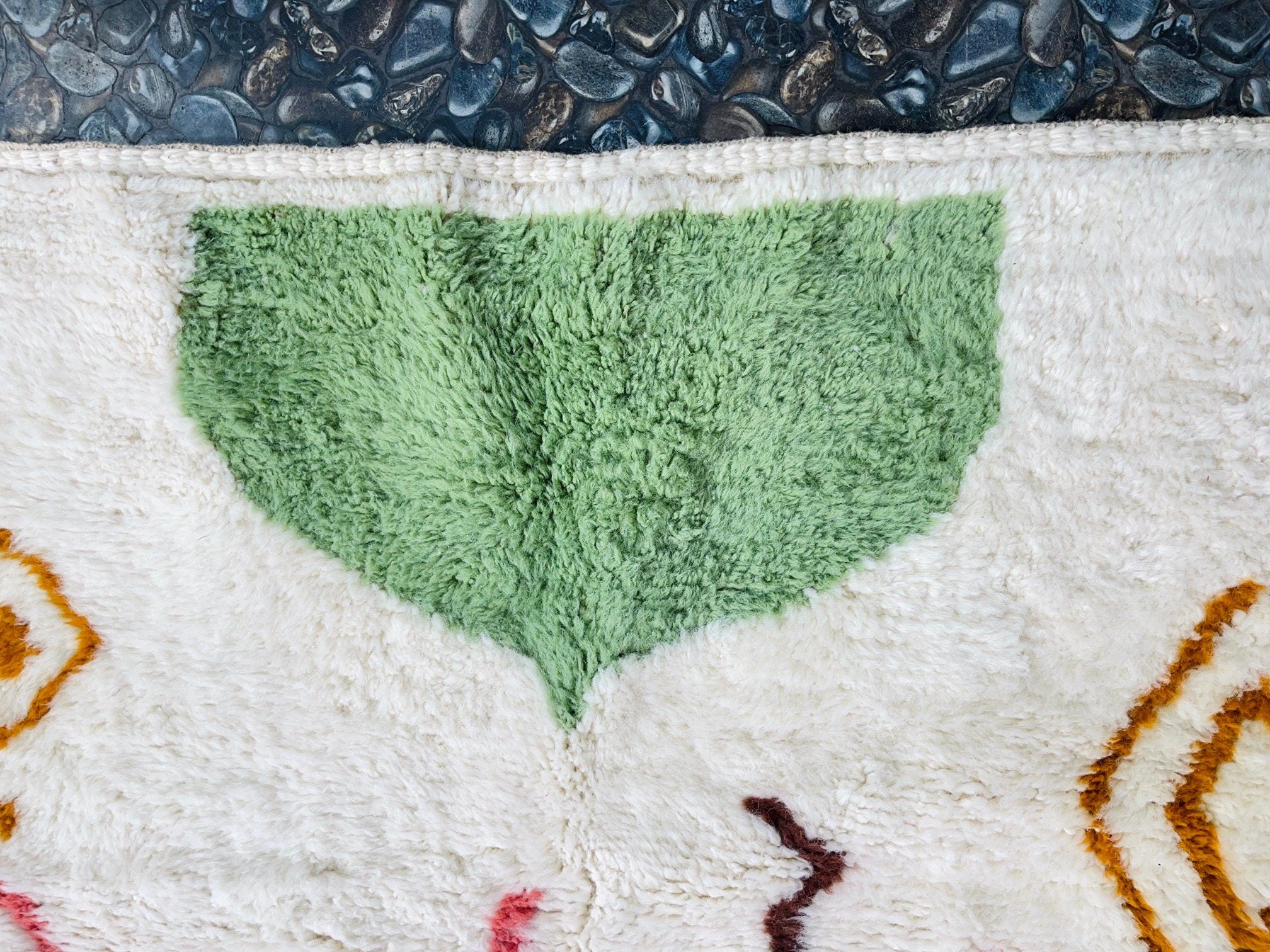 green patterned rug on textured background surface