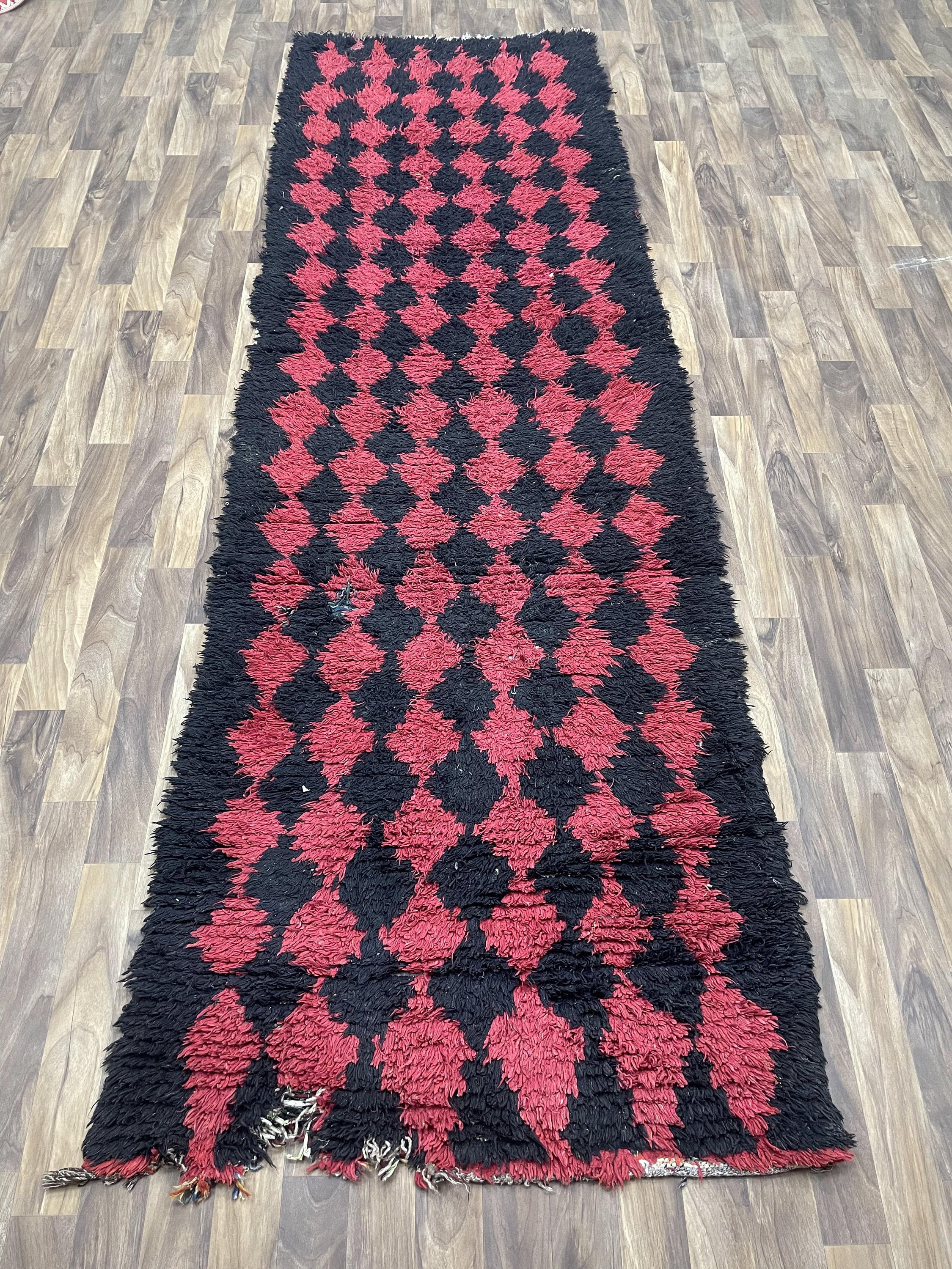 Red and black diamond patterned rug, adding style to any home decor.