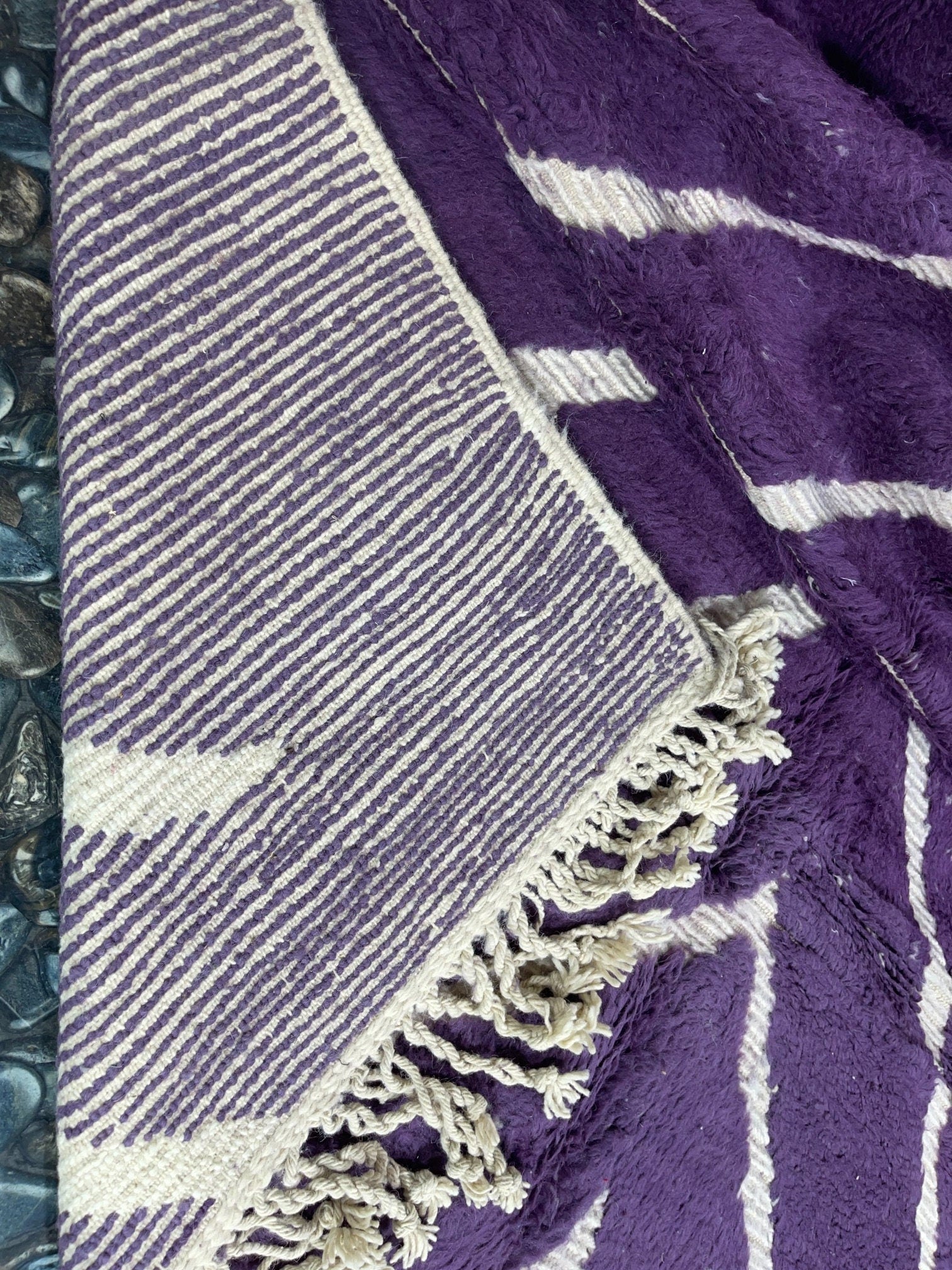 purple patterned blanket with fringed edges