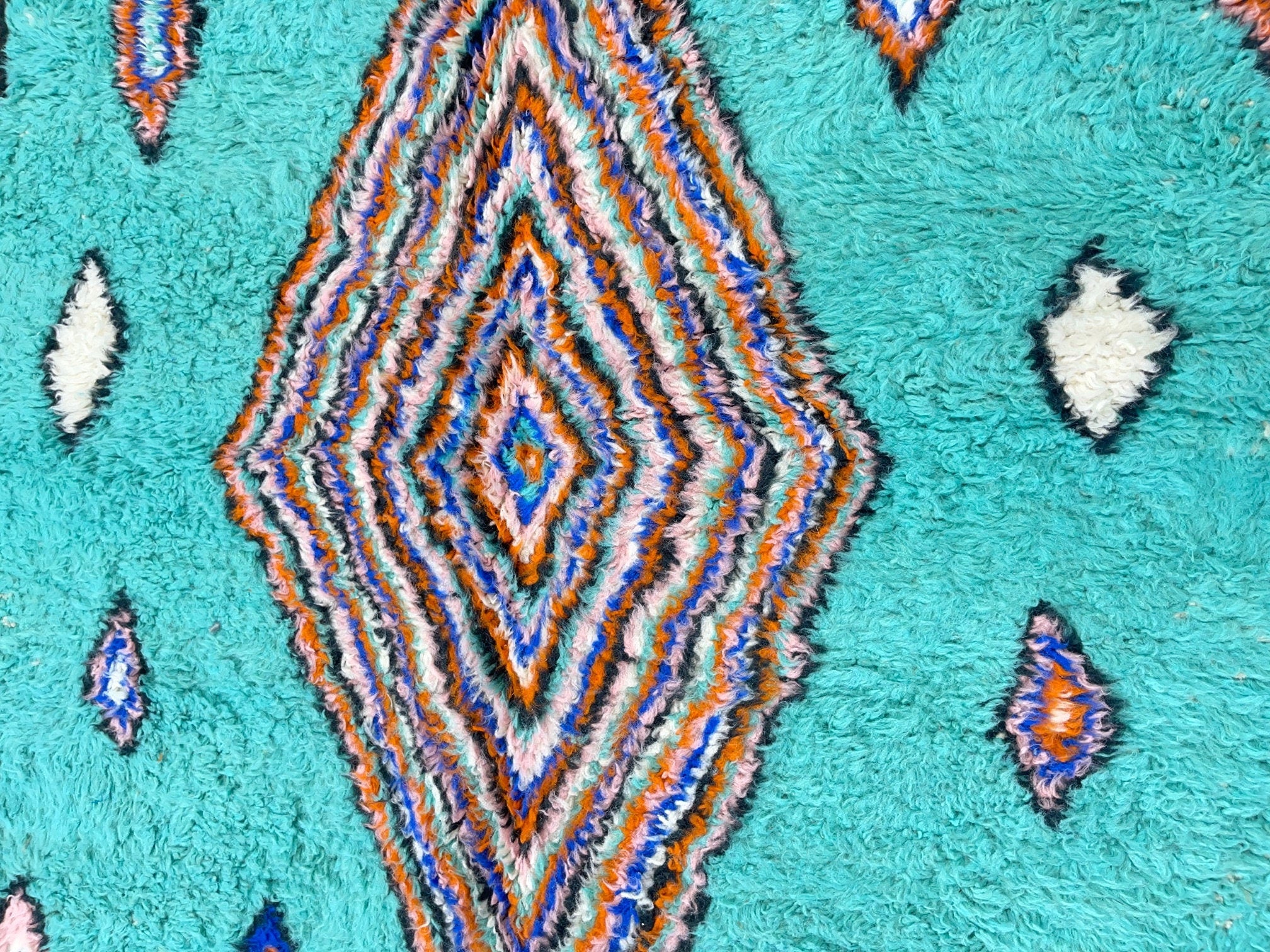 colorful geometric pattern on teal textured rug