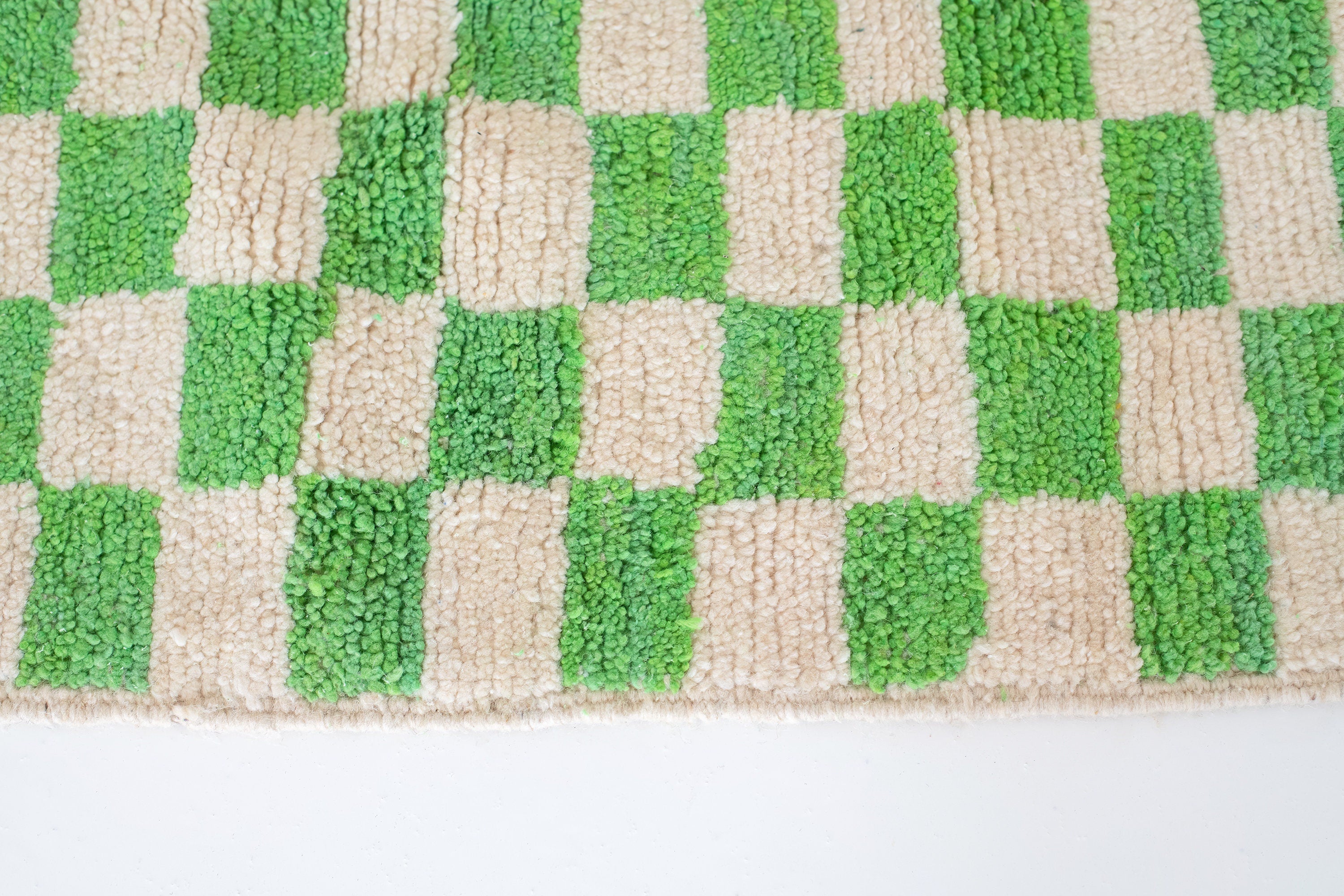 green and beige checkered rug close up