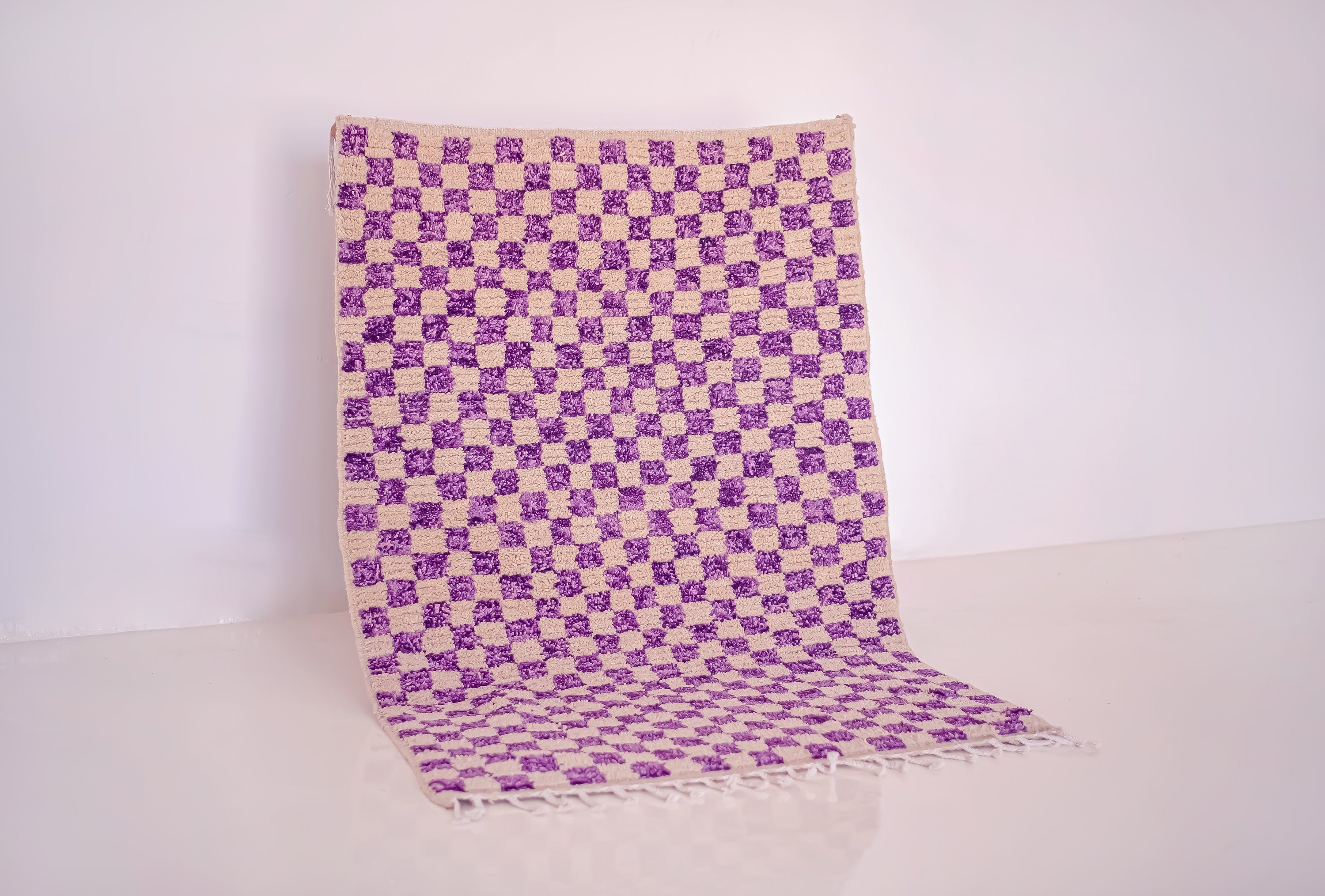 purple and cream checkered rug on floor