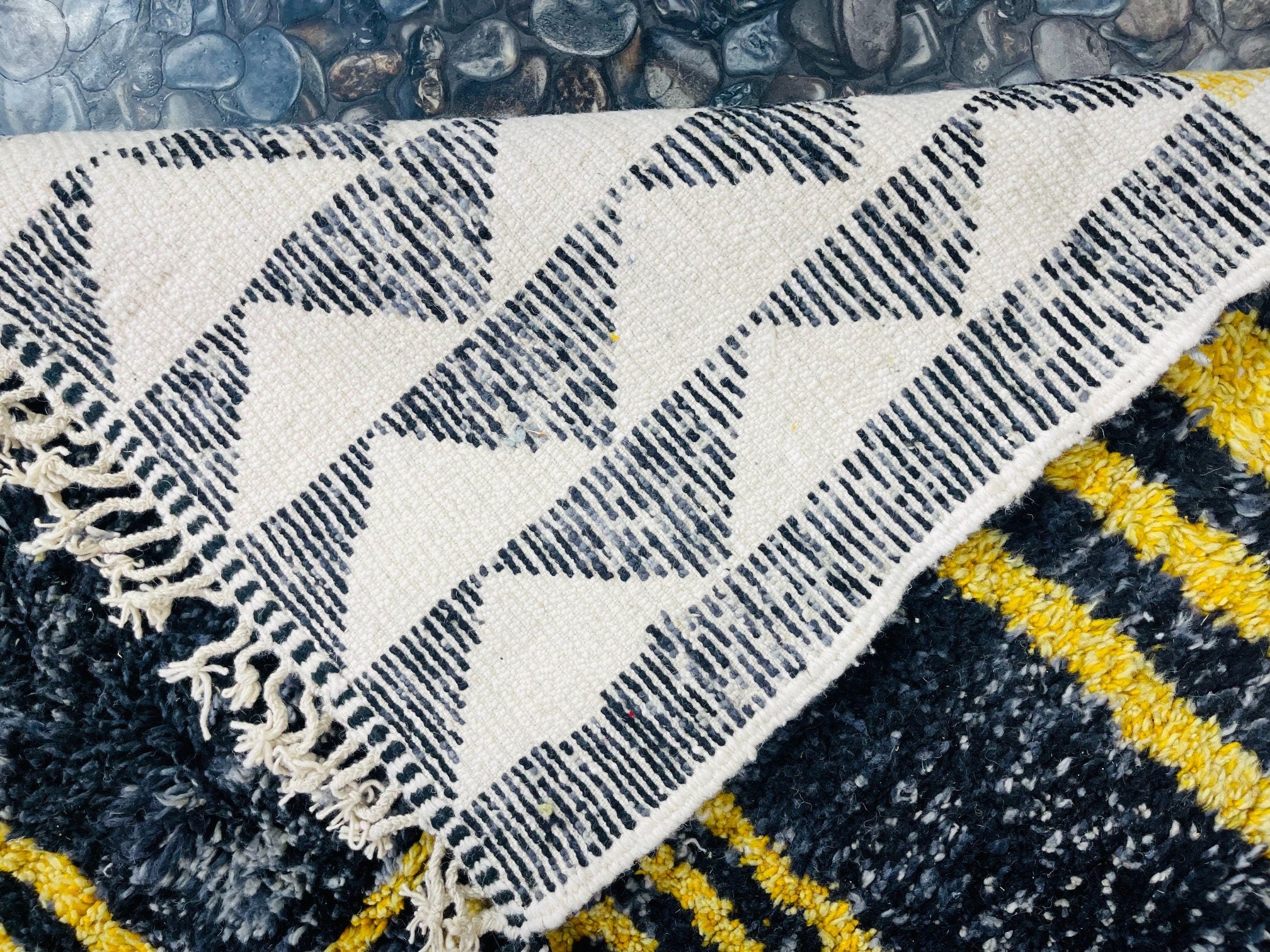 black and white patterned rug with fringes