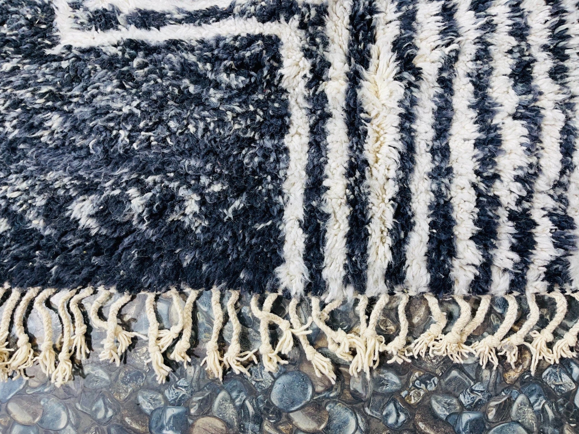 blue and white patterned rug on rocks