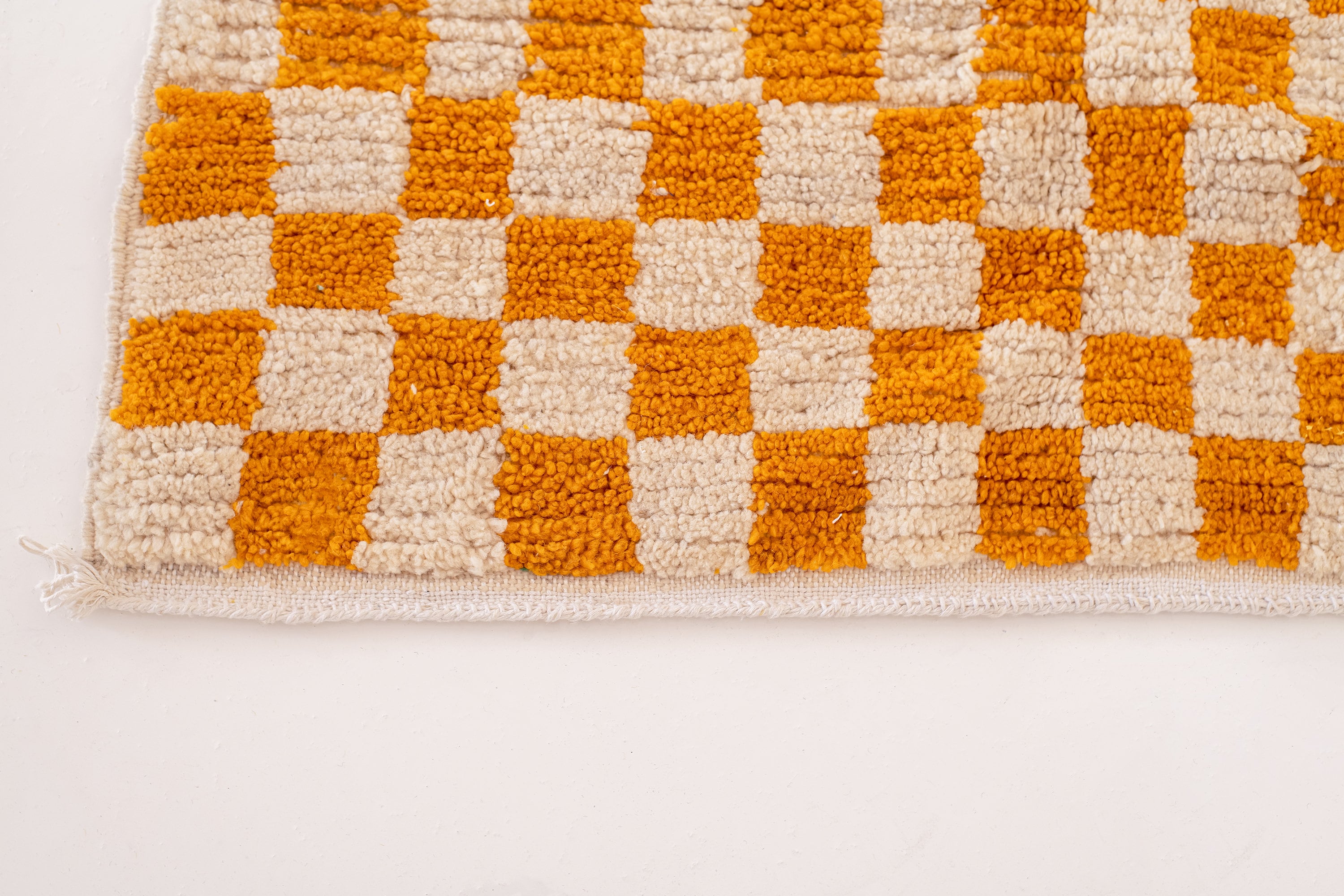 orange and cream checkered patterned rug closeup