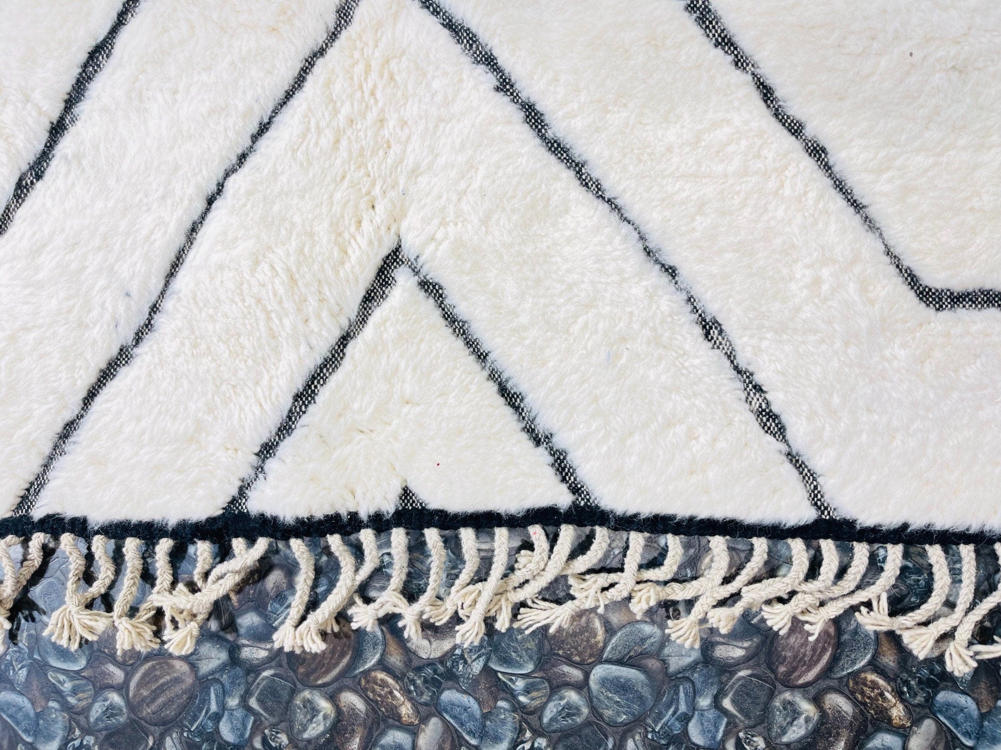 cream rug with black geometric patterns and fringe