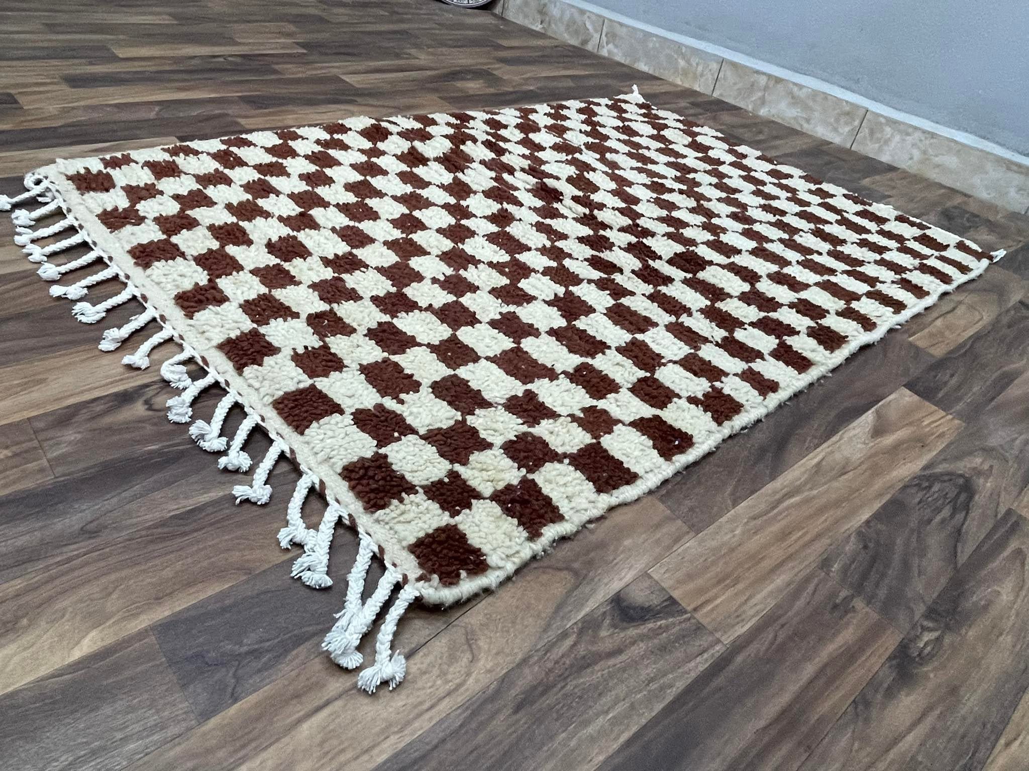 Checkered brown and cream area rug with decorative fringes, perfect for home decor.