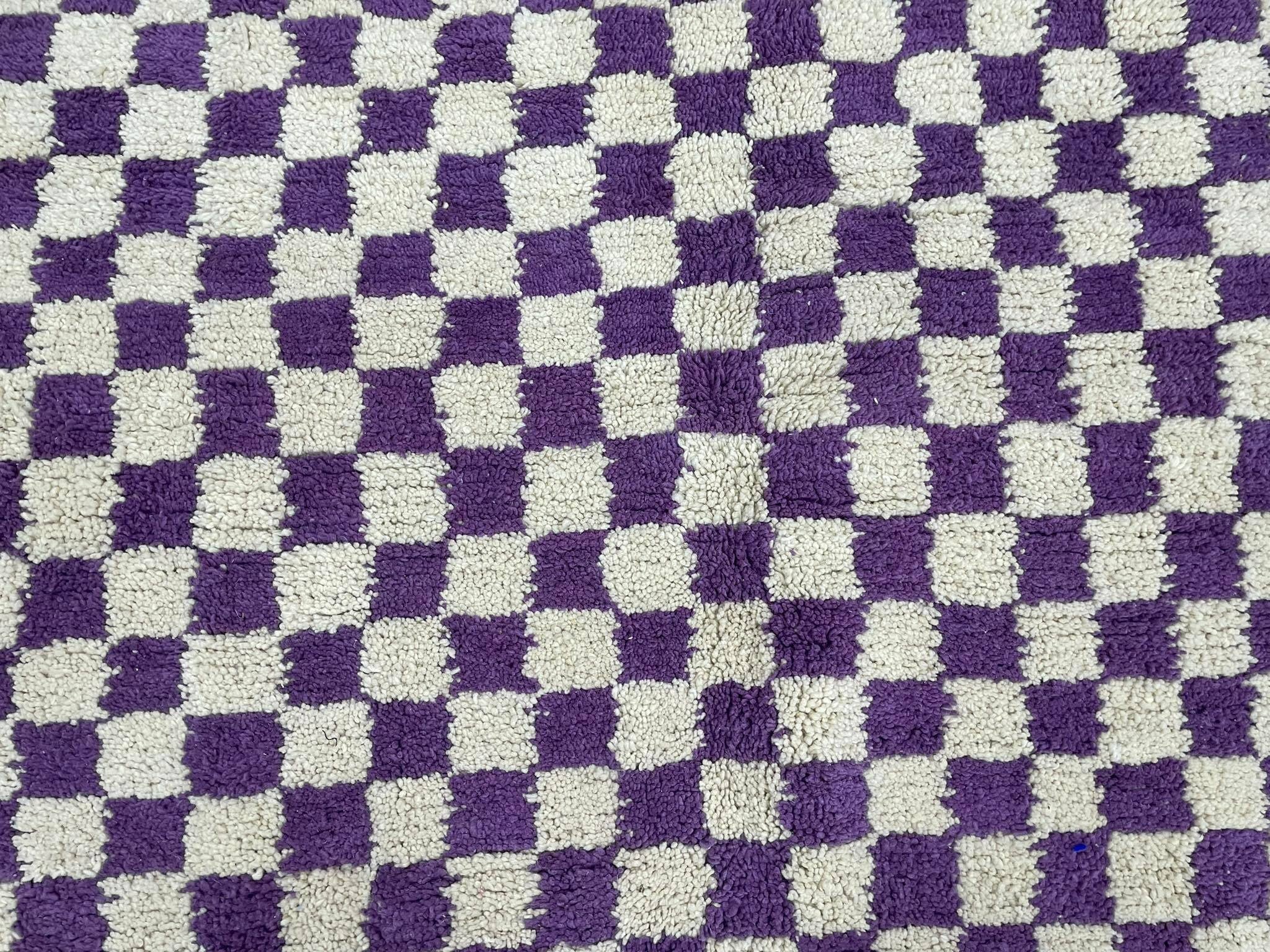 Purple and cream checkered rug, soft textile for home decor and comfort.