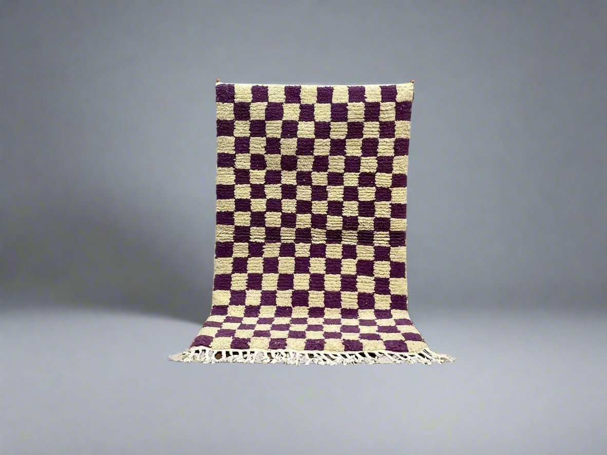 Purple and cream checkered rug with fringed edges, perfect for home decor.