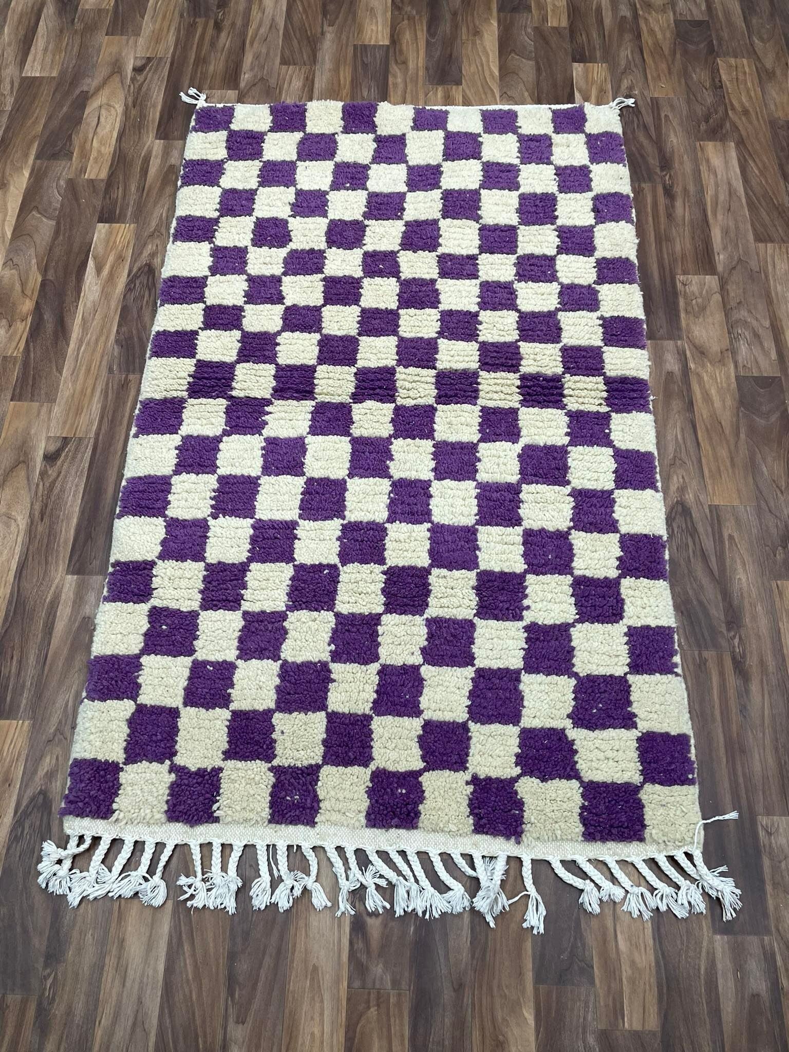 Purple and cream checkered area rug with fringed edges for stylish home decor.