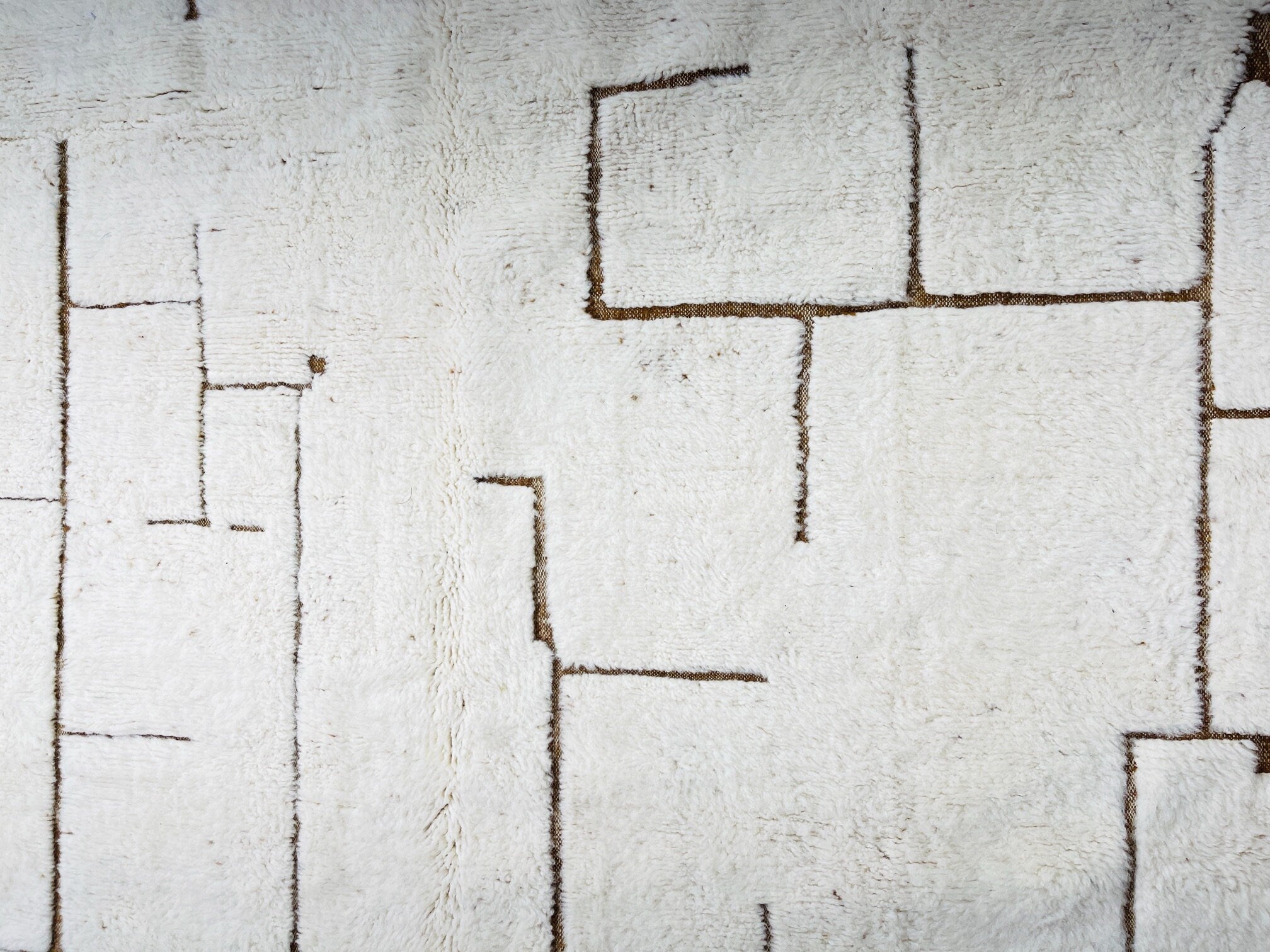 white textured rug with geometric brown pattern