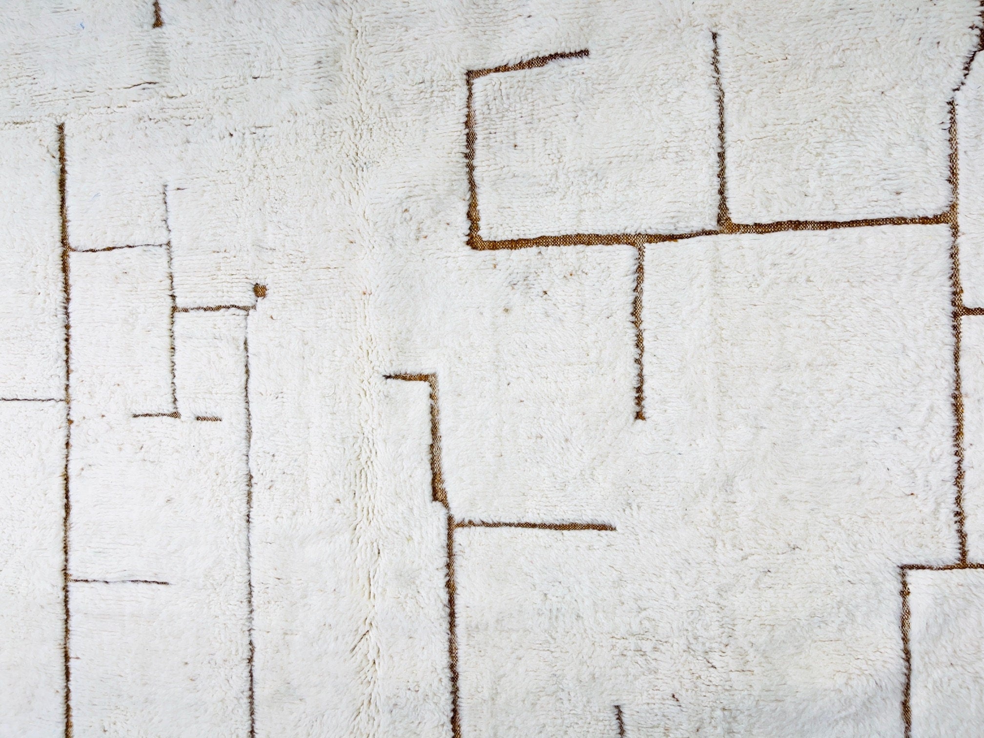 textured white rug with geometric brown lines